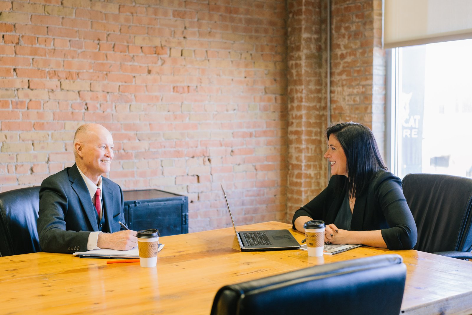 a man and woman sit at a table having a meeting